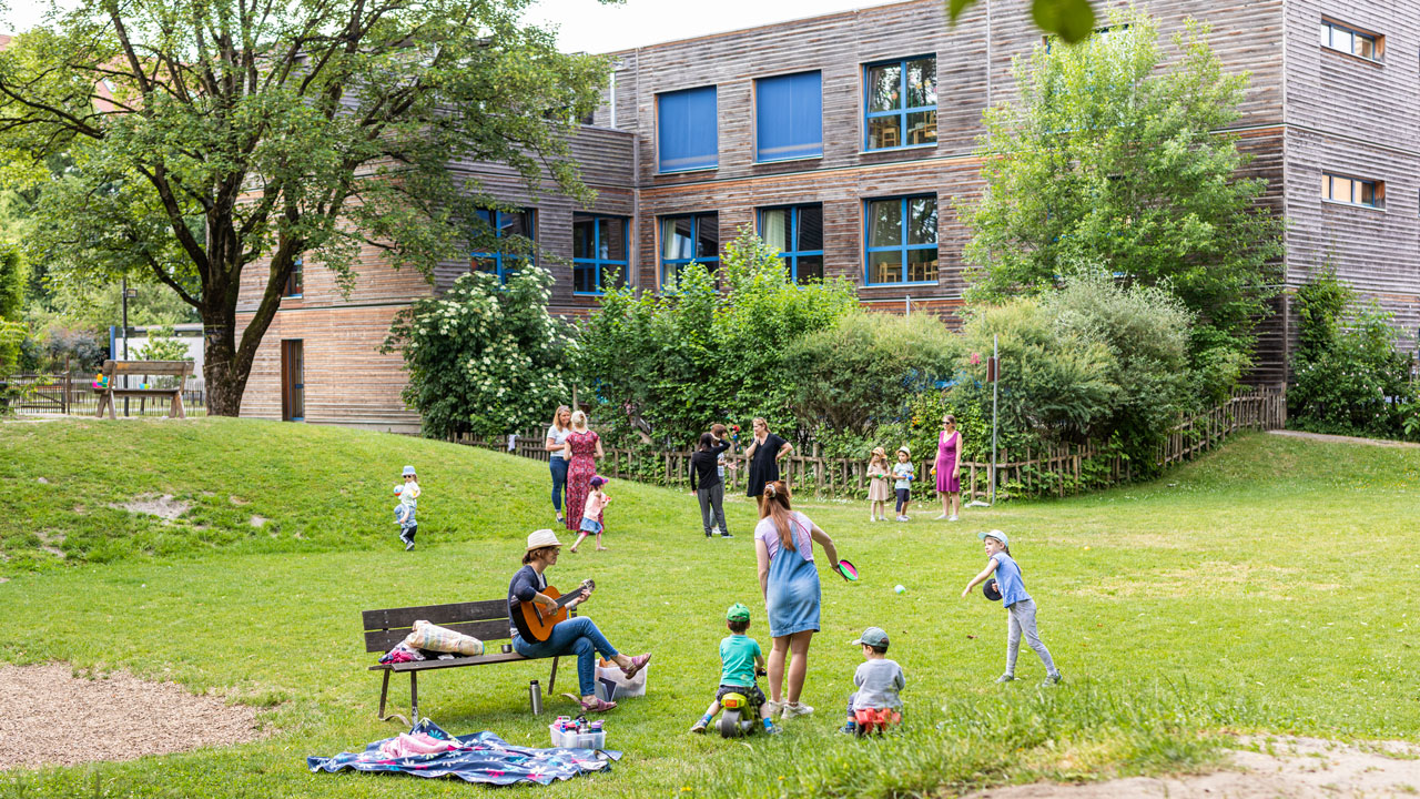 Kinder und Fachkräfte spielen im Garten der Einrichtung in Schwabmünchen